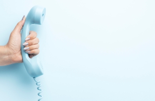 Imagem mostrando uma mulher segurando um telefone.